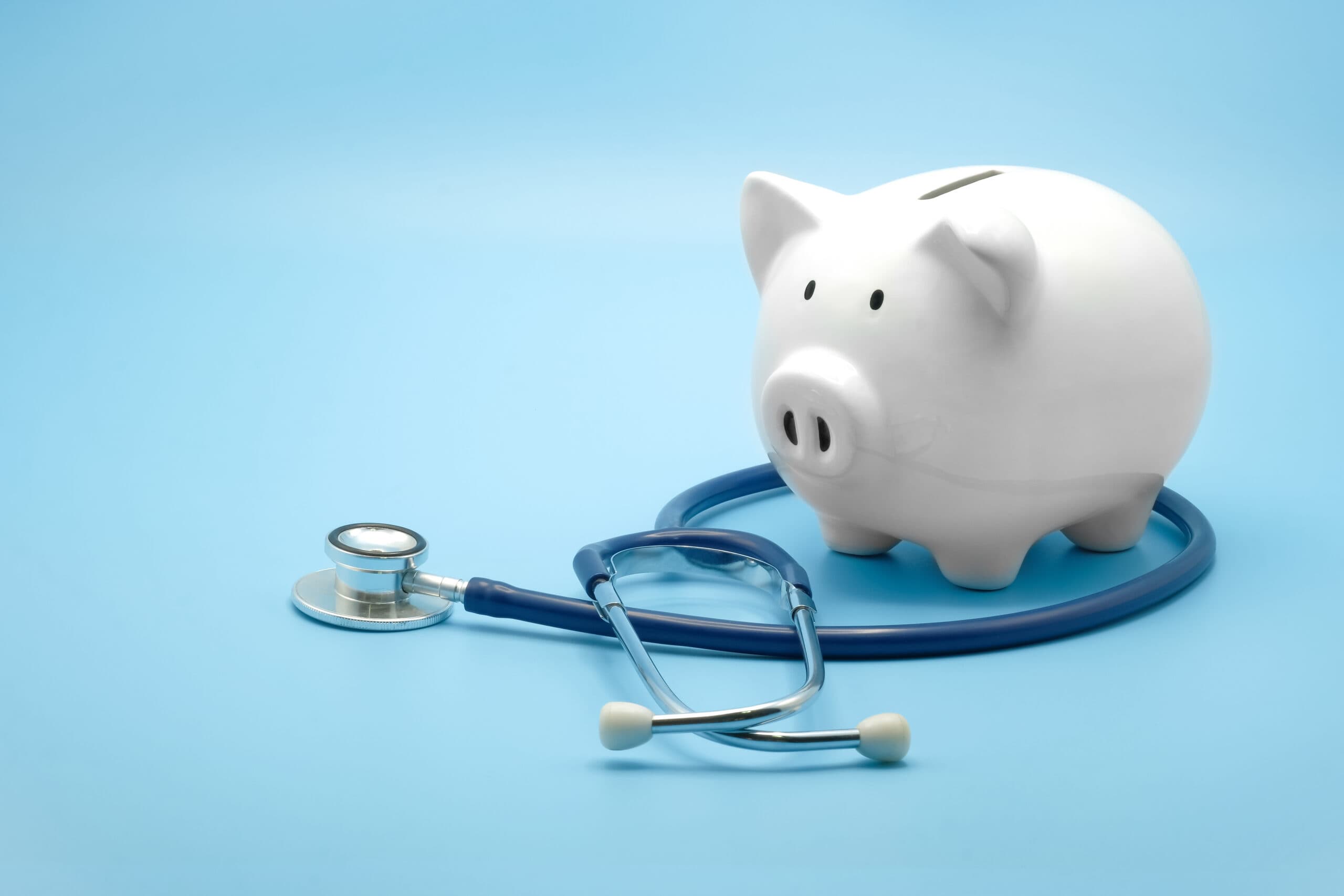 White piggy bank sitting on a stethoscope, representing health savings account planning