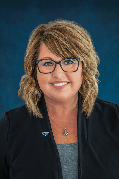 Smiling Croghan Bank employee with blonde hair and glasses wearing a black blazer with a blue lapel pin