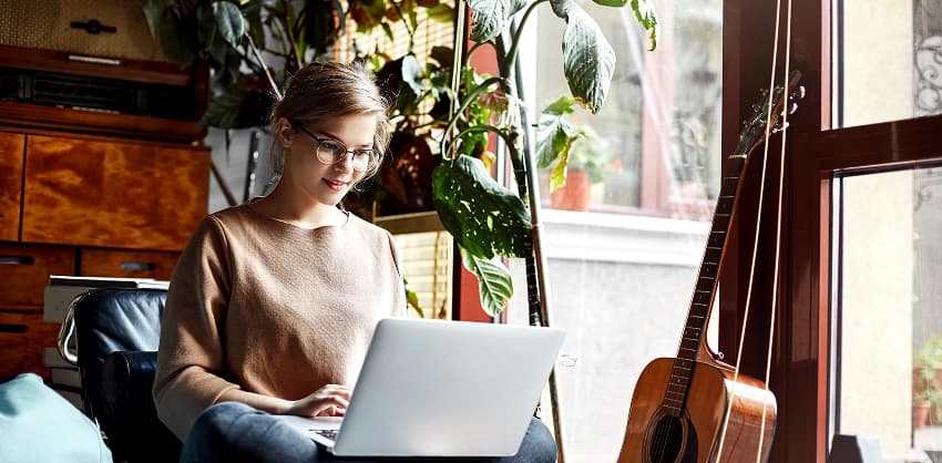 Woman with glasses using online banking on a laptop at home