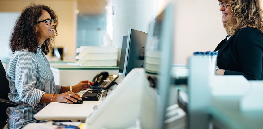 Bank receptionist smiling with a customer at the front desk of Croghan Bank