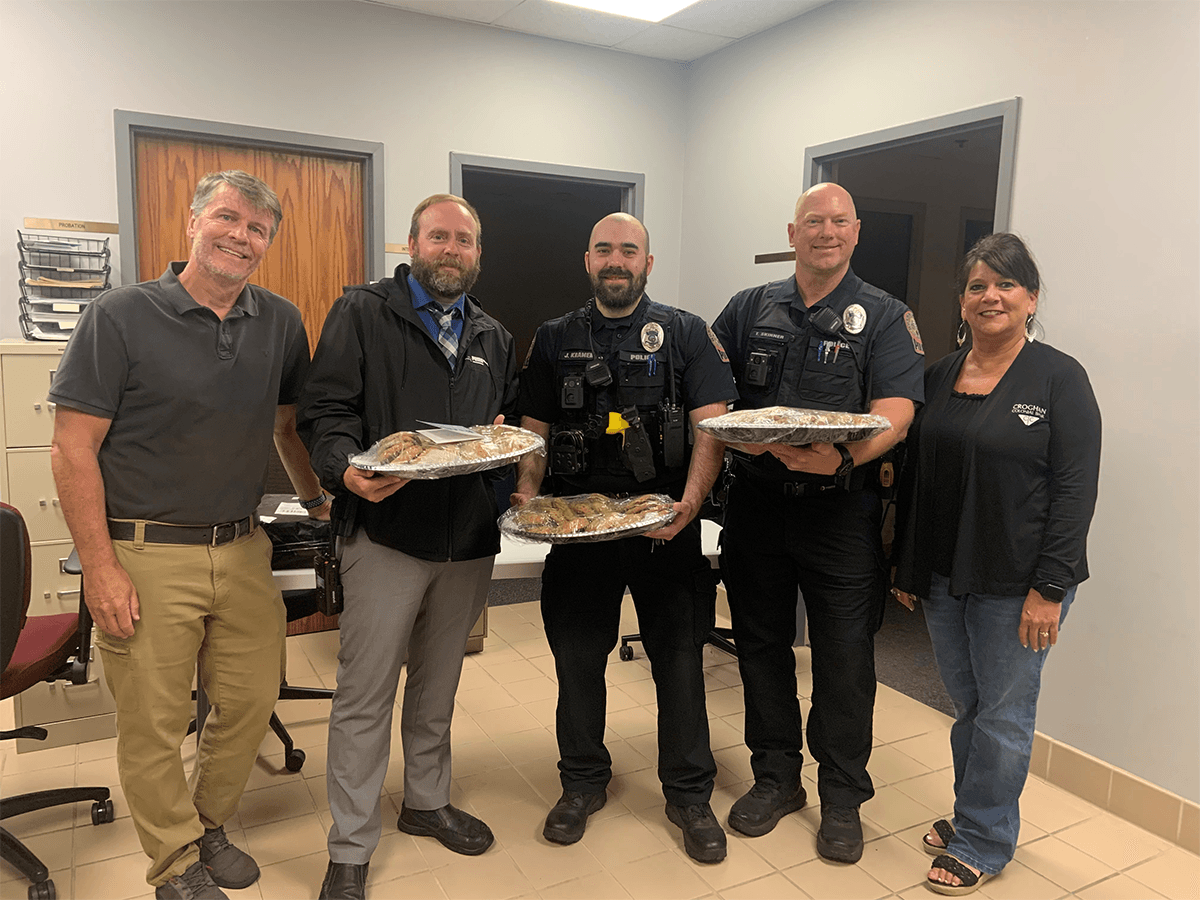 Croghan Bank staff presenting baked goods to local police officers in uniform
