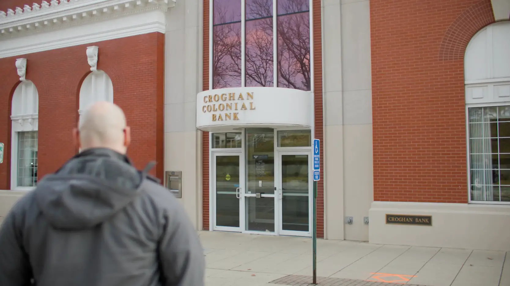 Person approaching the entrance of Croghan Colonial Bank branch