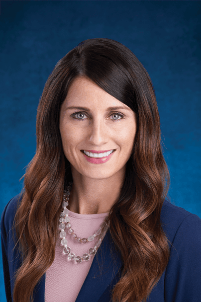 Croghan Bank professional with long hair smiling in a navy blazer and pearl necklace