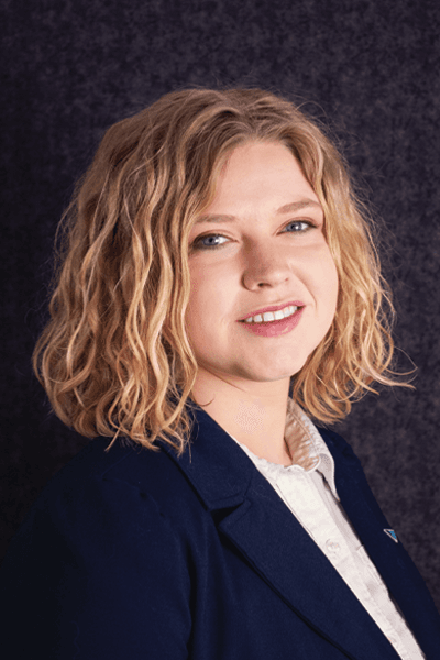Croghan Bank team member in a navy blazer with curly blonde hair smiling warmly