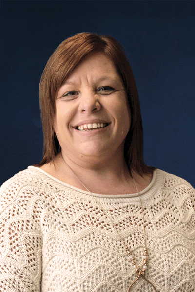 Smiling Croghan Bank employee with reddish-brown hair wearing a cream knit sweater