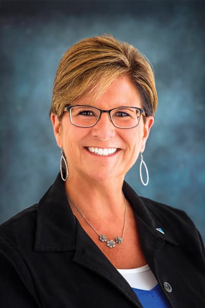 Smiling Croghan Bank professional woman with short blonde hair, glasses, and a black blazer