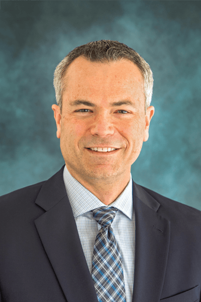 Croghan Bank professional smiling in a dark suit and plaid tie