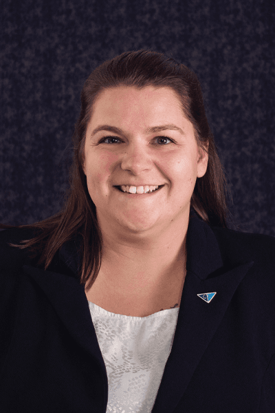 Smiling Croghan Bank team member in a black blazer with a blue triangle pin