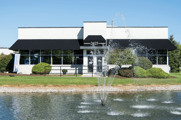 Modern office building with fountain pond and manicured landscaping at 3425