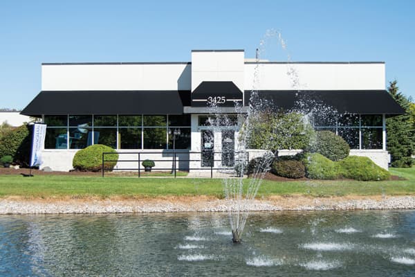 Modern office building with fountain pond and manicured landscaping at 3425