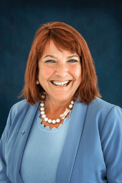Smiling Croghan Bank professional woman with red hair wearing a blue blazer and pearl necklace