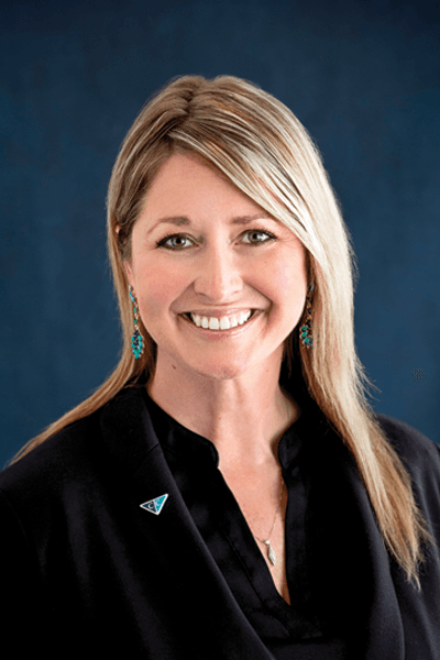 Smiling Croghan Bank professional woman with long blonde hair wearing a black blazer and teal earrings