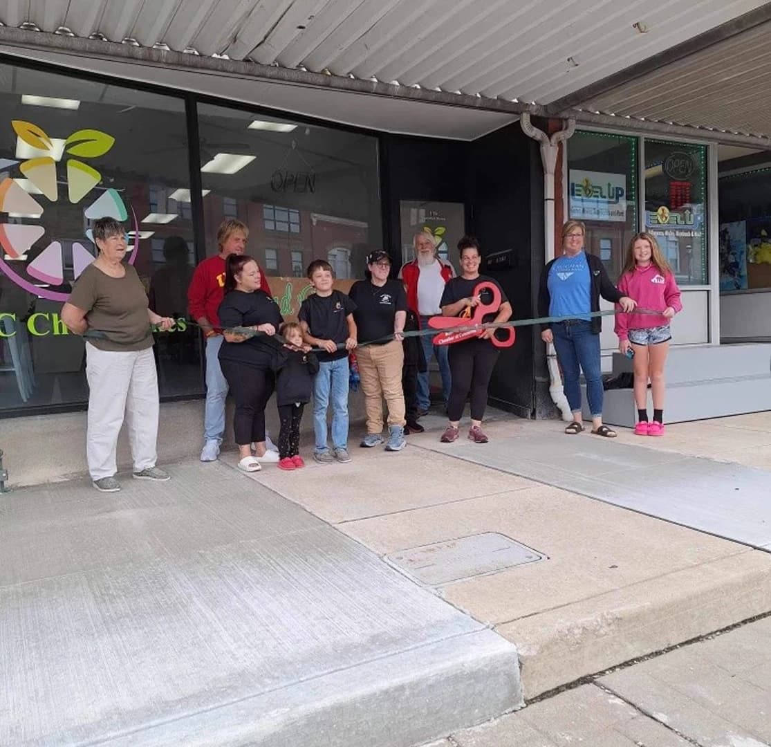 Small business ribbon cutting ceremony outside a local shop with community members