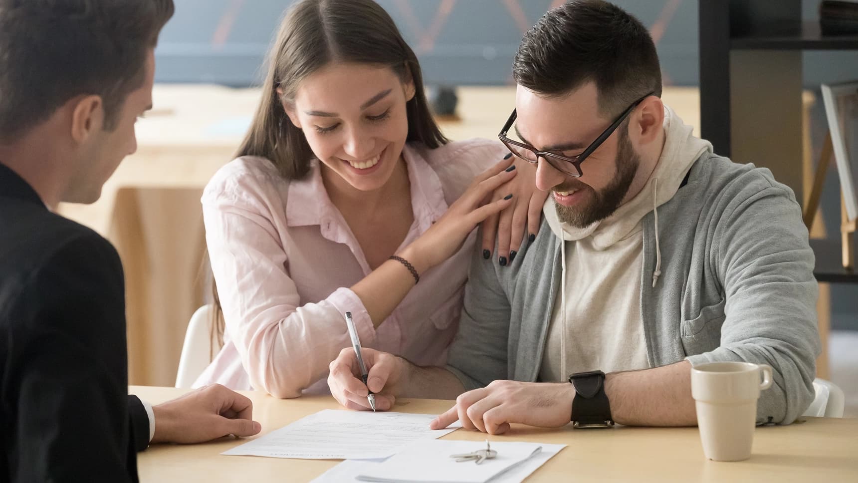 Couple signing documents with an advisor to finalize a home loan agreement