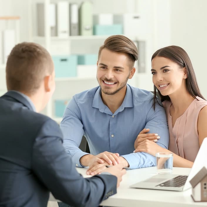 Smiling couple meeting with a financial advisor to discuss mortgage loan options