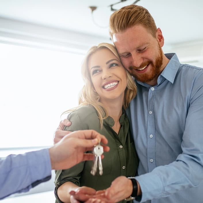Couple receiving keys after closing on a home with mortgage loan financing
