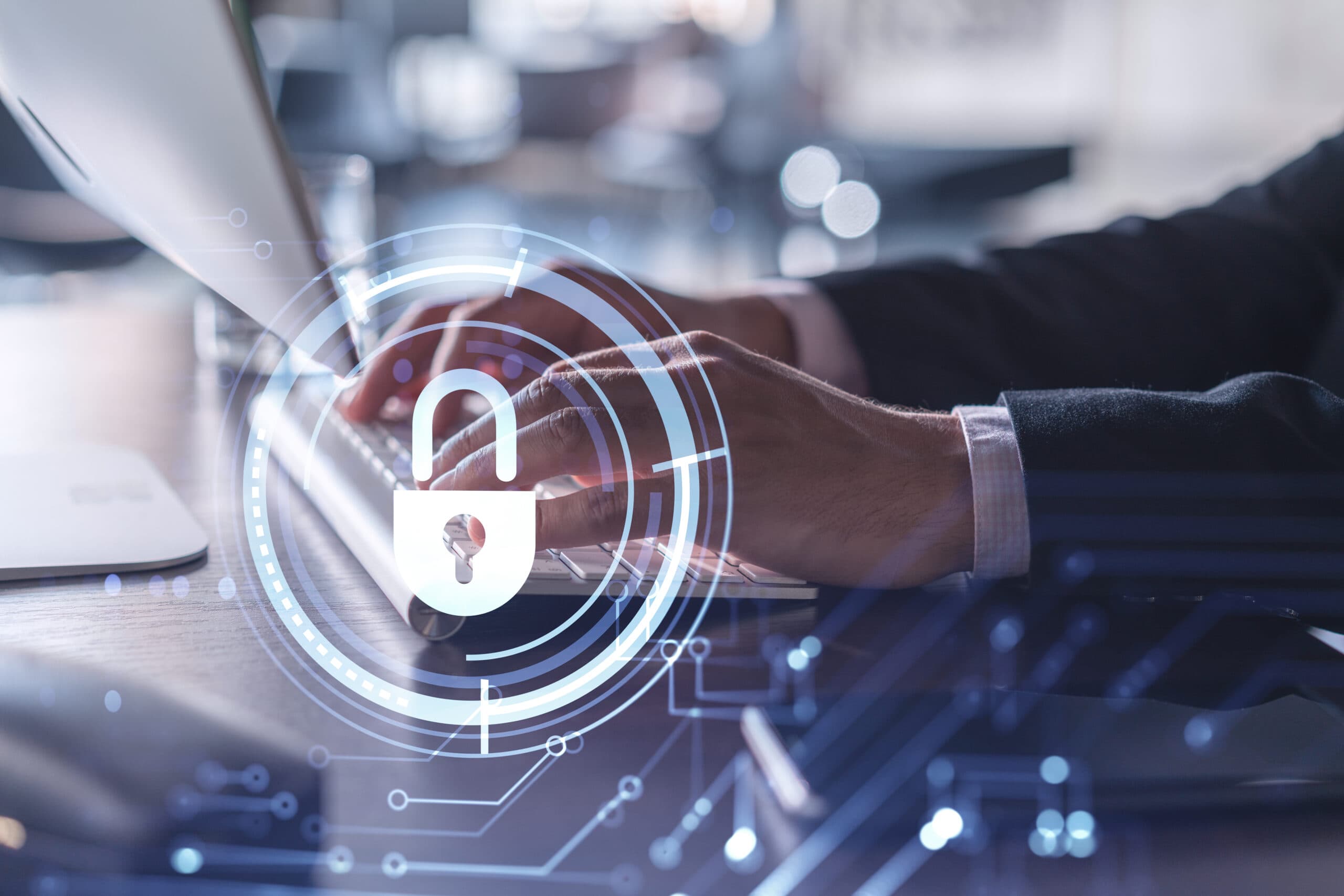 Person typing on a keyboard with a glowing digital padlock cybersecurity overlay