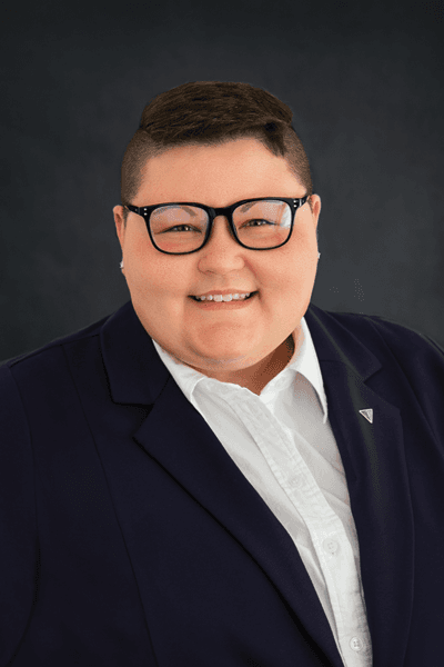 Smiling Croghan Bank staff member wearing glasses and a navy blazer with a blue lapel pin