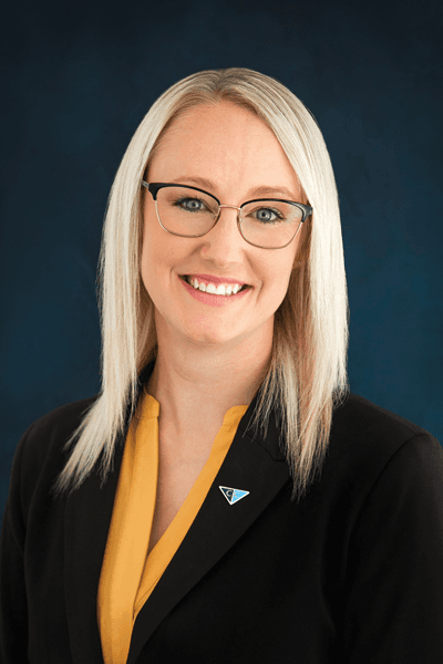 Smiling Croghan Bank female staff member with blonde hair and glasses wearing a black blazer and gold top