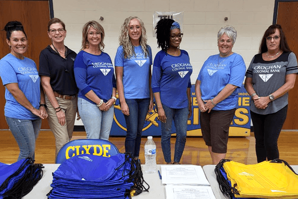 Croghan Colonial Bank volunteers distributing Clyde school backpacks at a community event
