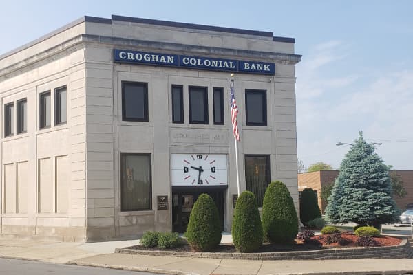 Croghan Colonial Bank main branch with stone exterior, large clock, and "Established 1888" inscription
