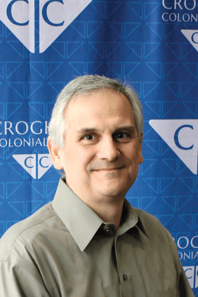 Croghan Colonial Bank employee smiling in front of branded blue backdrop