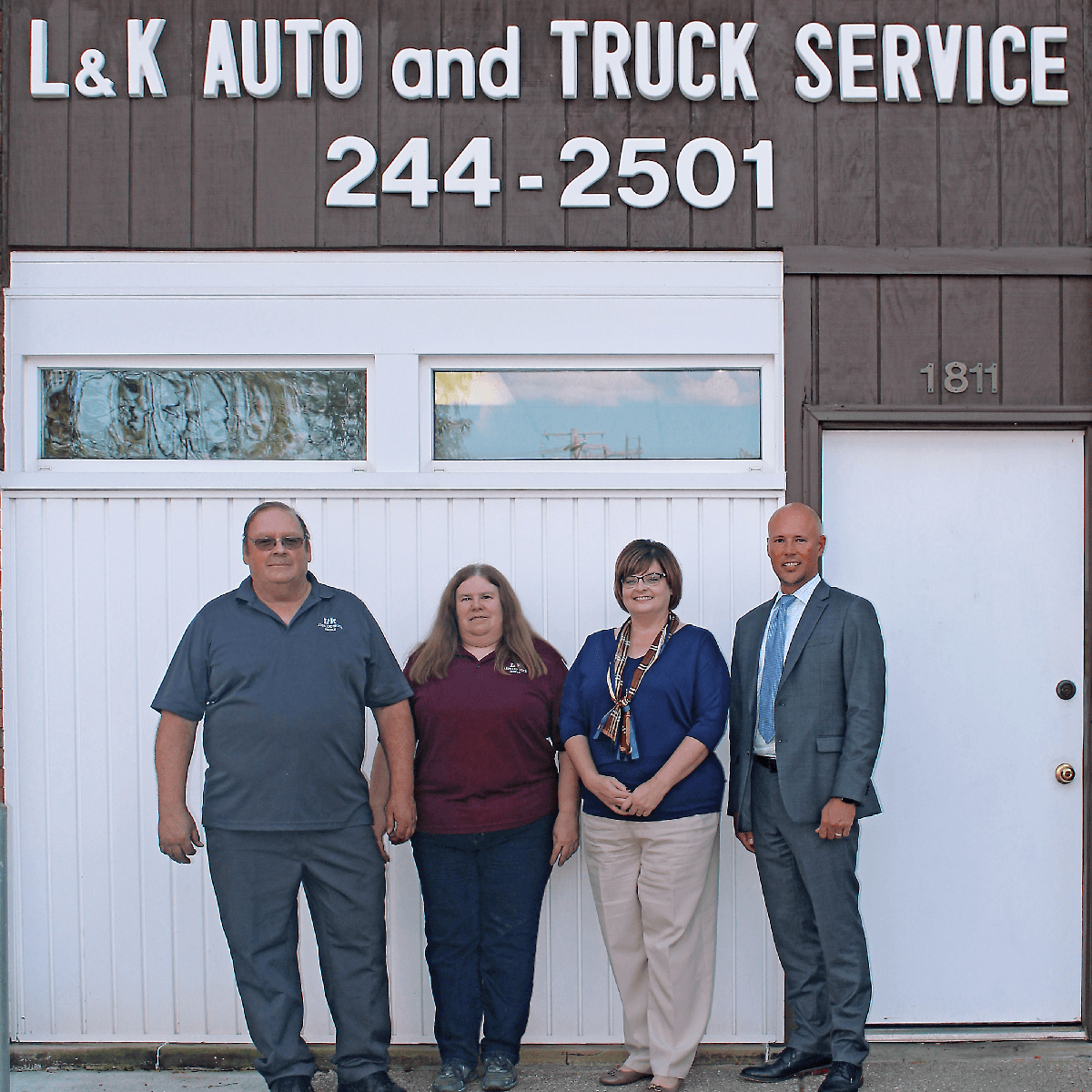 Four people standing in front of L&K Auto and Truck Service, a Croghan Bank small business loan client