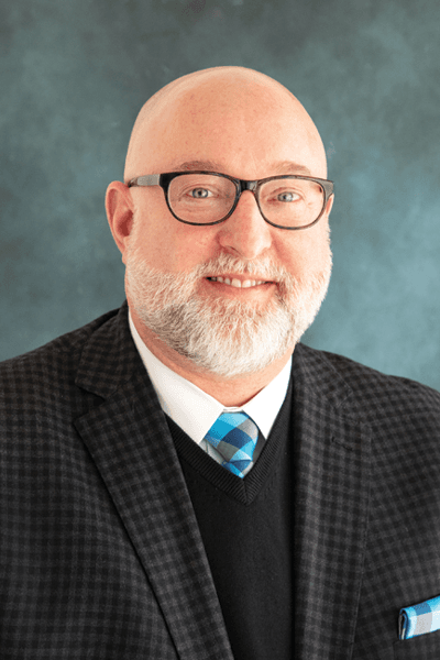 Croghan Bank professional man with glasses and beard wearing a suit and tie against a gray background
