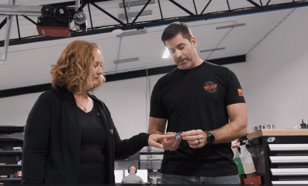 A Croghan Bank representative showing a customer a small item in a modern workspace