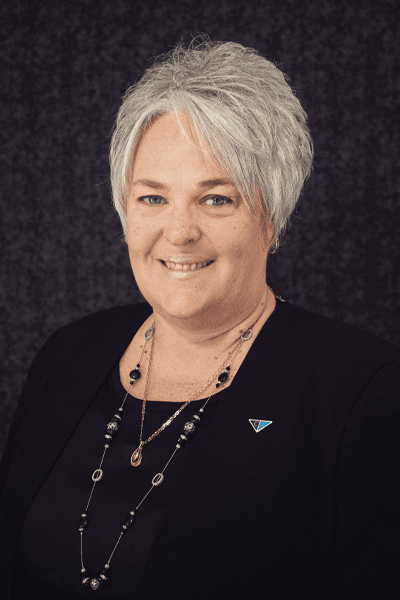 Smiling Croghan Bank team member with short gray hair wearing a black top and blazer