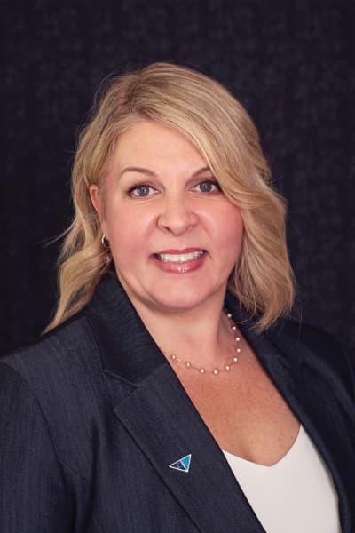 Smiling Croghan Bank professional woman with blonde hair wearing a gray blazer and pearl necklace