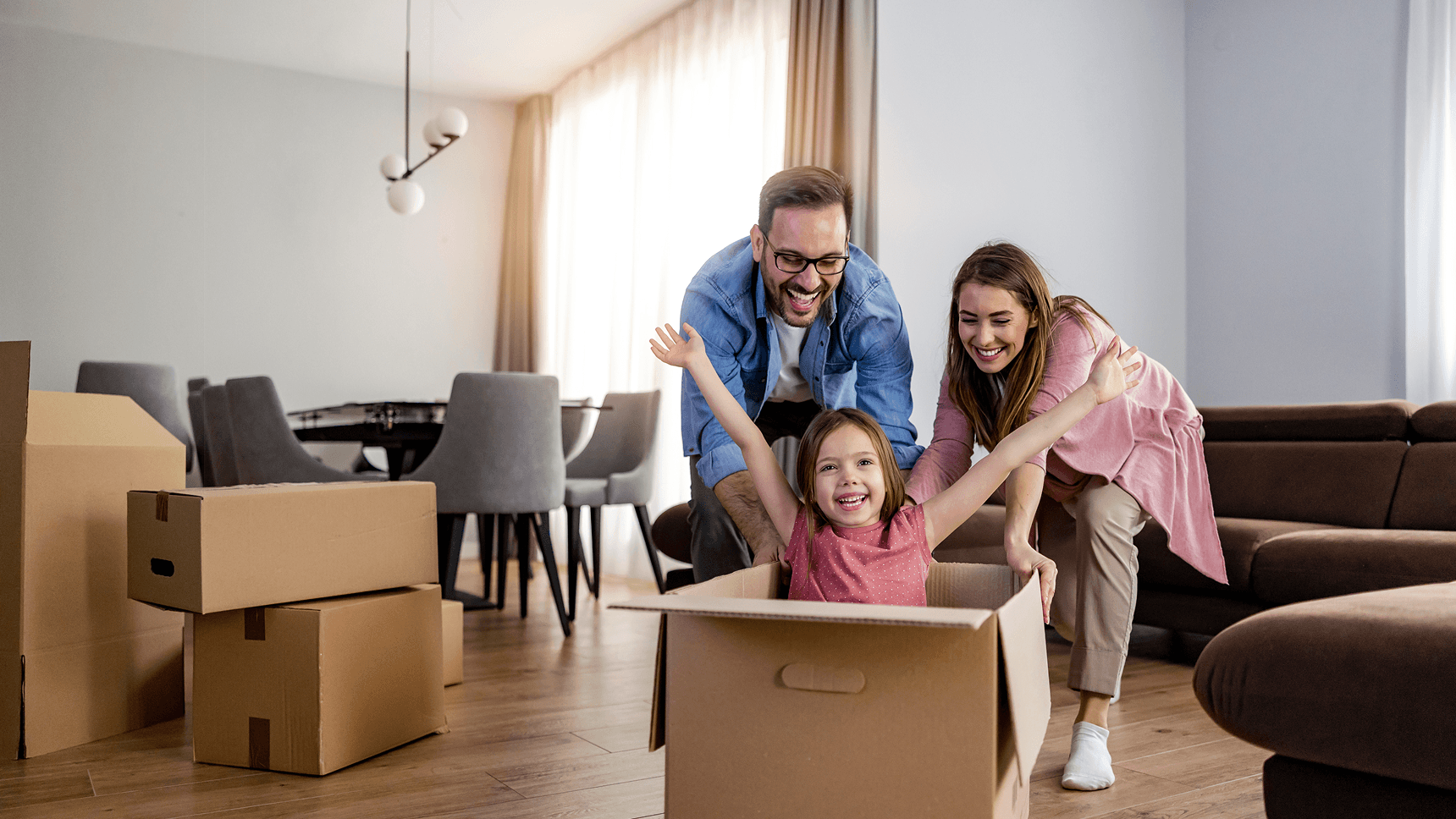 A joyful family playing with moving boxes in their new home