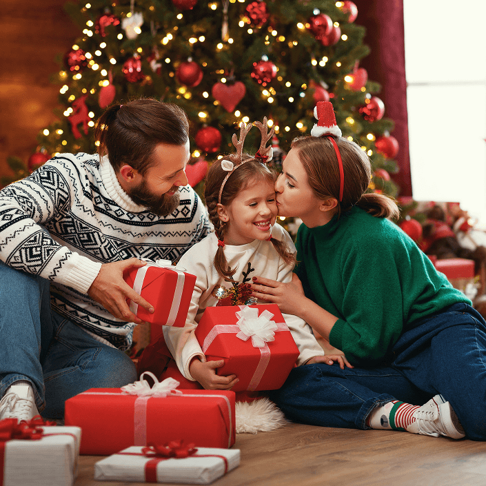 Family celebrating Christmas morning together with gifts near a decorated tree