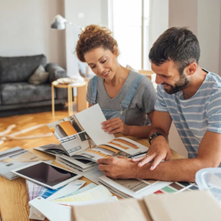 Couple reviewing home improvement plans and color swatches at a table