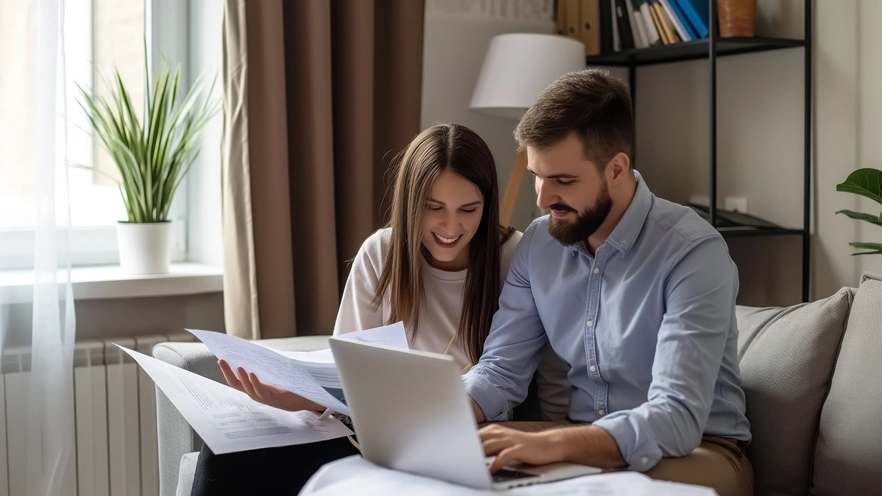 Couple reviewing home loan documents together on a laptop at home