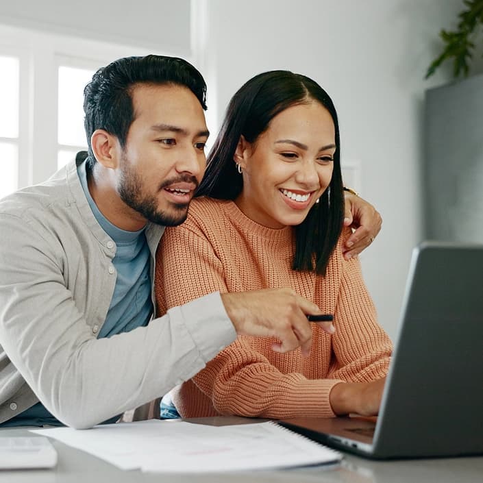 Couple reviewing mortgage loan options together on a laptop at home