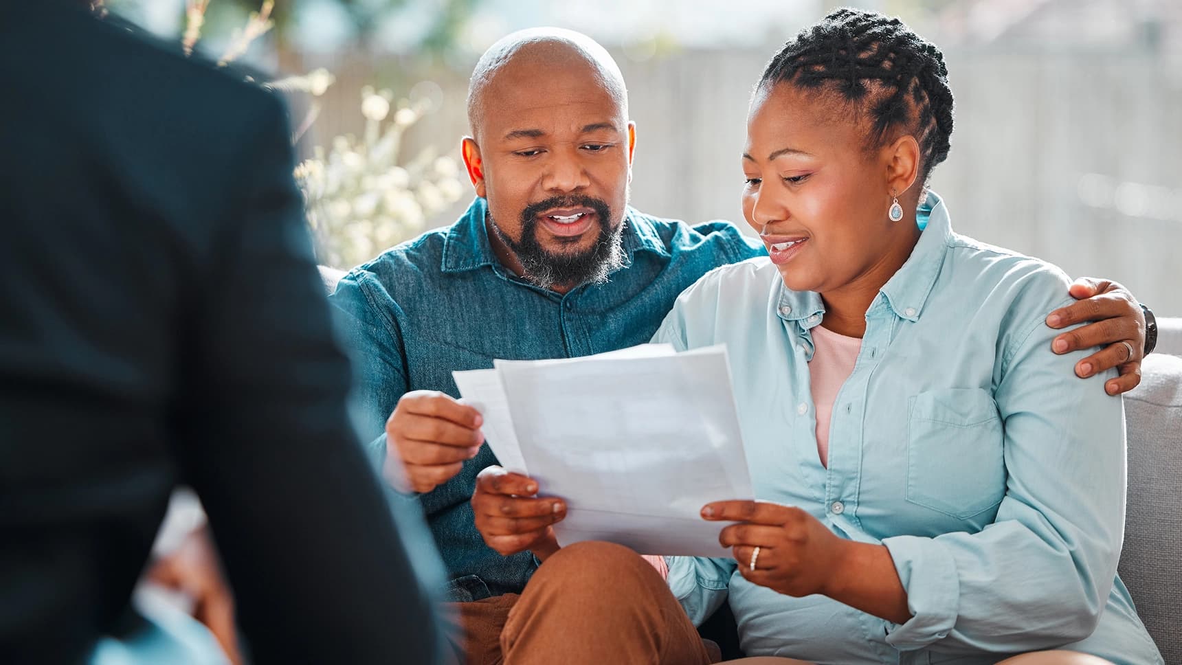 Couple reviewing mortgage loan or financial documents with an advisor