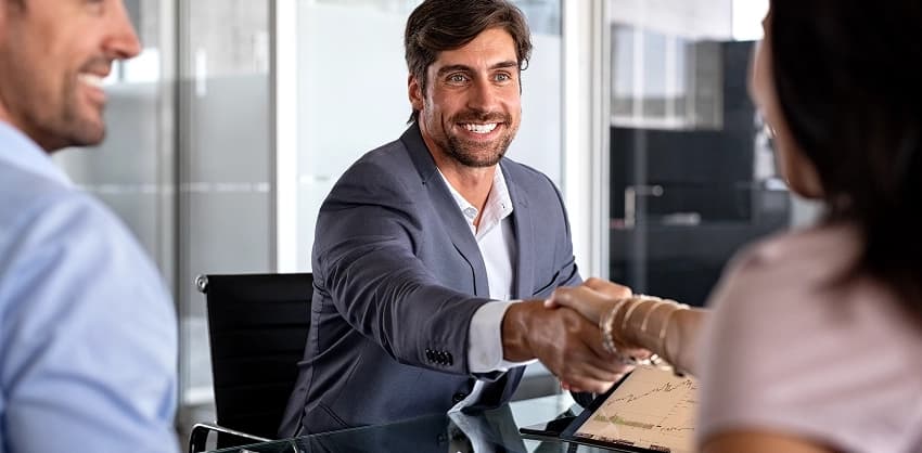 Smiling banker shaking hands with a client after finalizing a business loan agreement