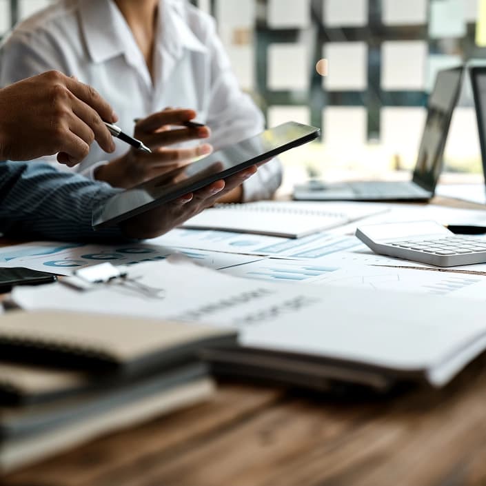 Financial advisor reviewing investment charts and reports on a tablet for wealth management