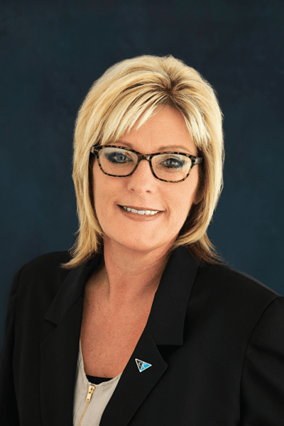 Smiling woman with blonde hair and glasses wearing a black blazer with a Croghan Bank pin