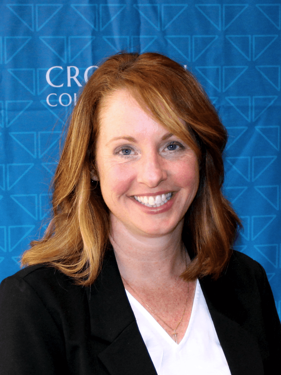 Croghan Bank professional with auburn hair smiling in front of a blue branded backdrop.