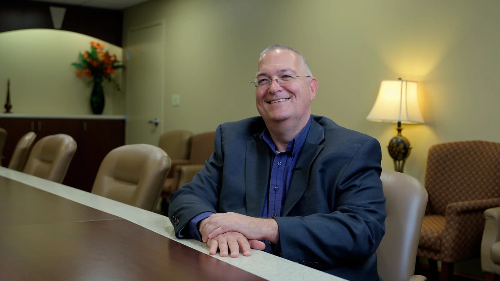 A smiling Croghan Bank professional in a blazer seated at a conference room table
