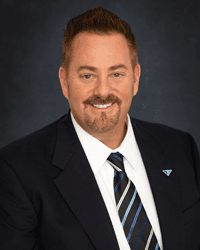 Professional man with a beard wearing a dark suit and striped tie with a Croghan Bank pin
