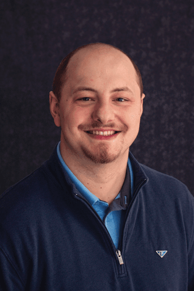 Smiling Croghan Colonial Bank team member in a blue zip-up sweater and collared shirt
